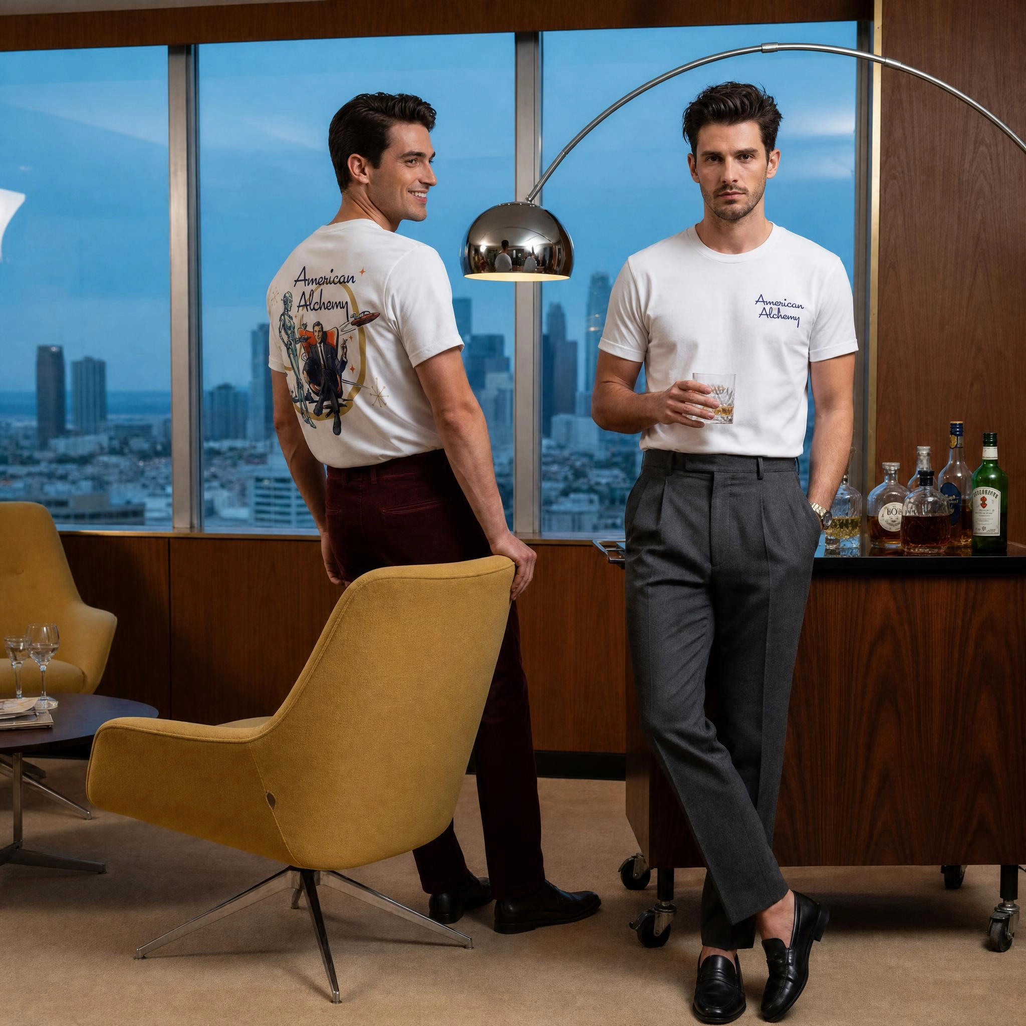 Two models in a mid-century penthouse bar at dusk wearing the white Atomic Age tee, city skyline behind them